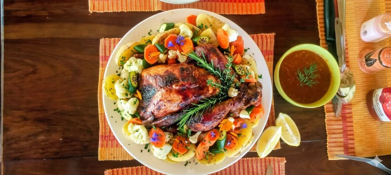 Roast chicken platter with vegetables and a bowl of soup