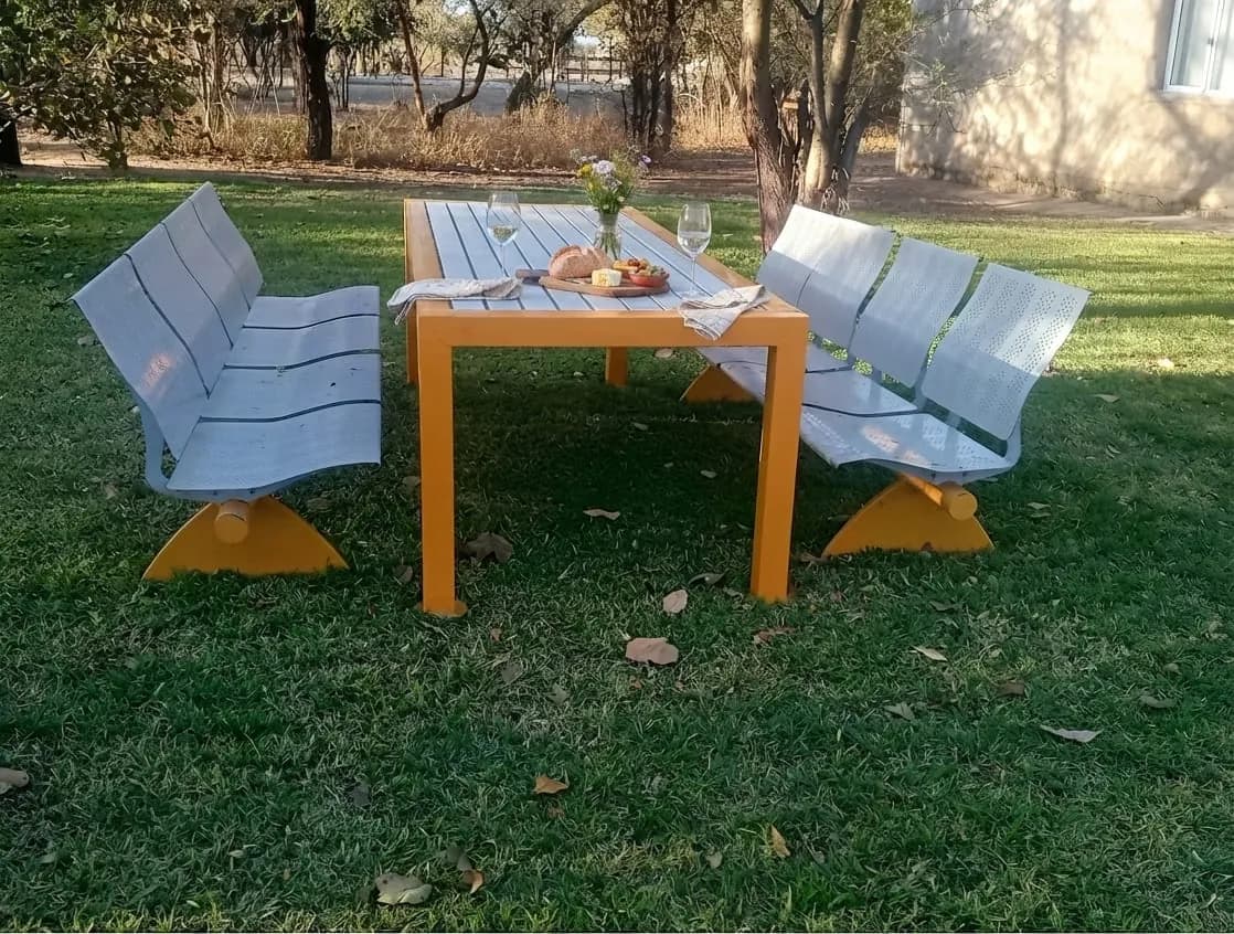 Orange table and pale benches set out on the lawn