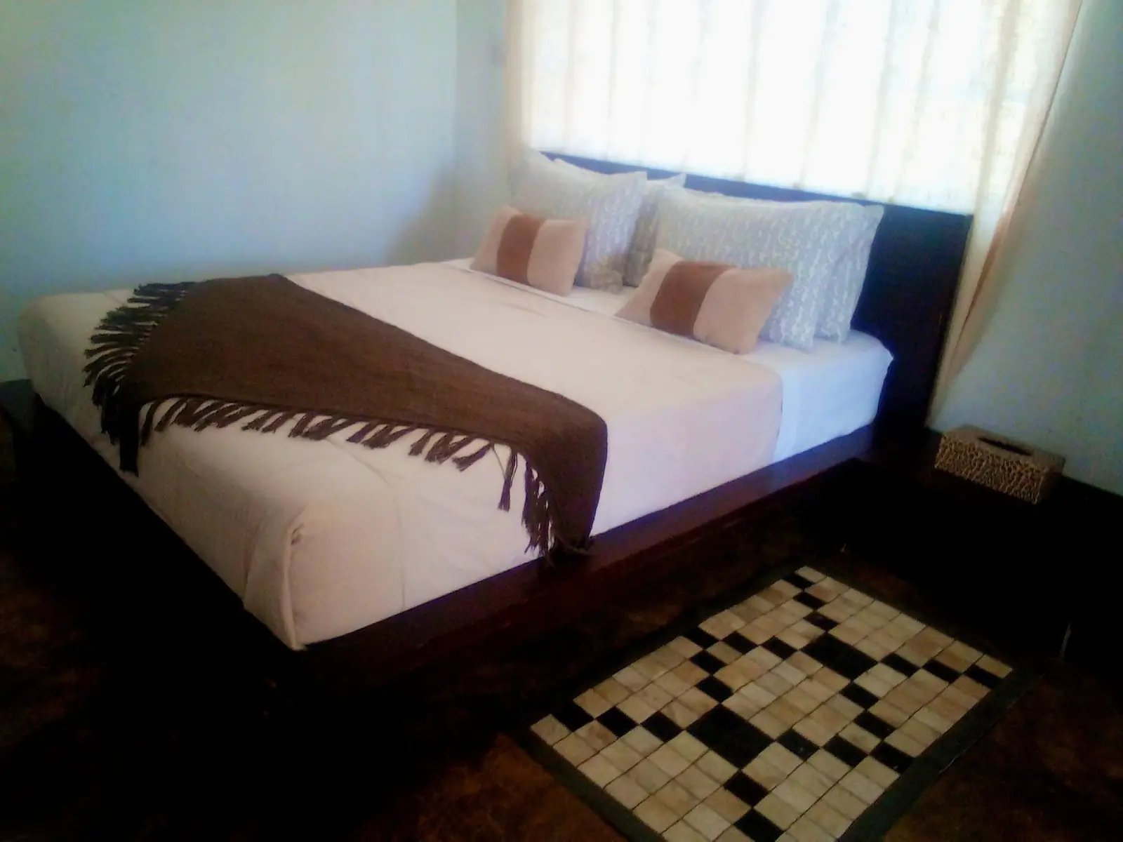 Double bed with a brown throw