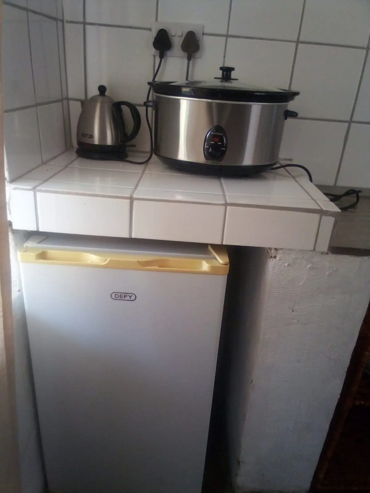 Kitchenette with fridge, kettle and slow cooker