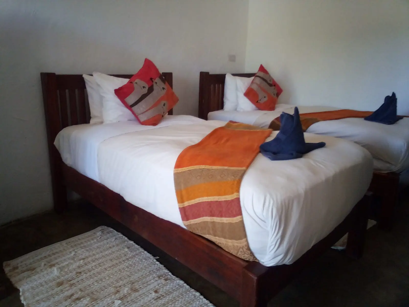 Self-catering twin room with orange cushions