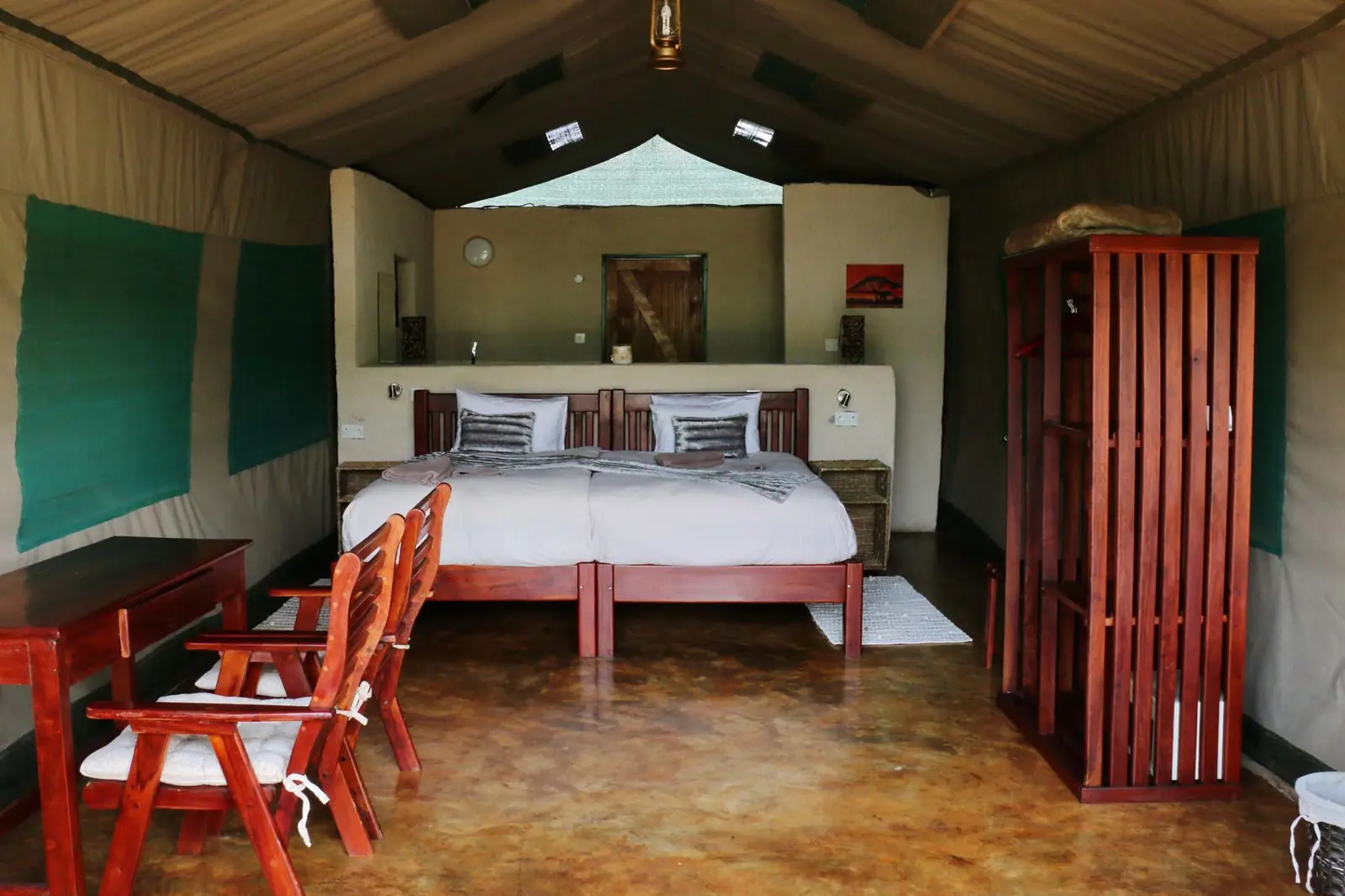 Tented chalet with twin beds and red chairs