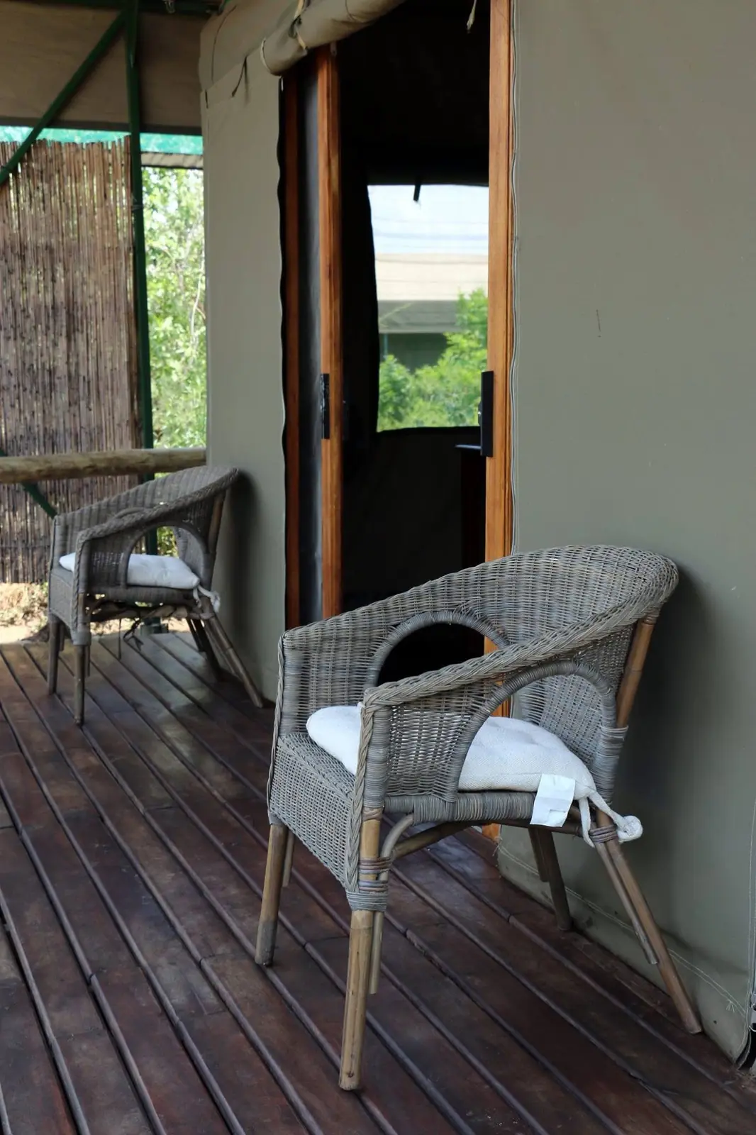 Two wicker chairs on a tent deck